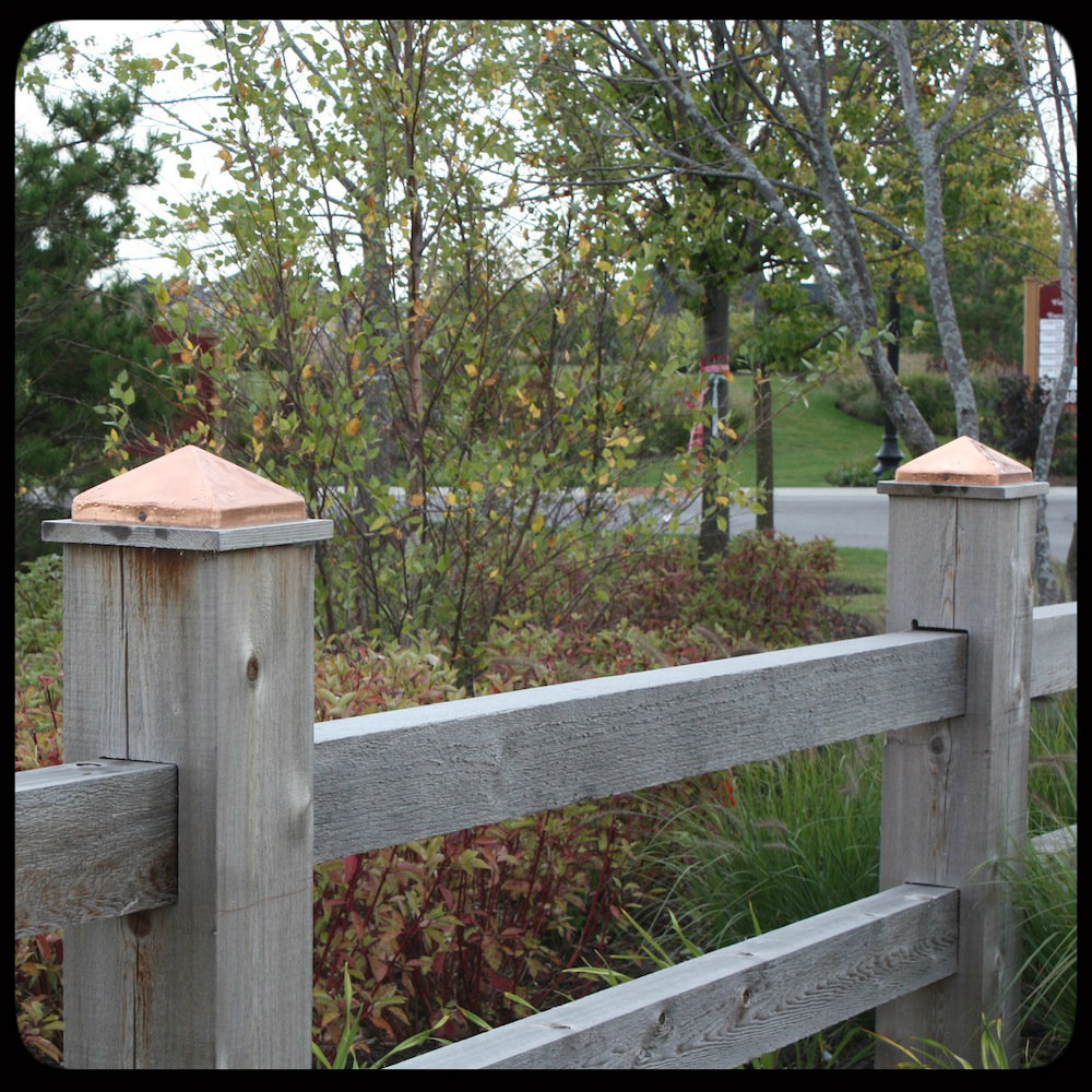 copper pyramid fence post caps on wooden fence